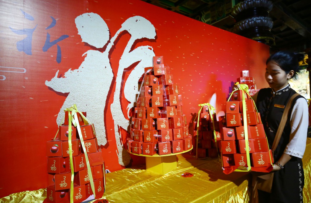 2月8日，工作人员在三亚南山迎财神庙会活动中准备摆放水果。